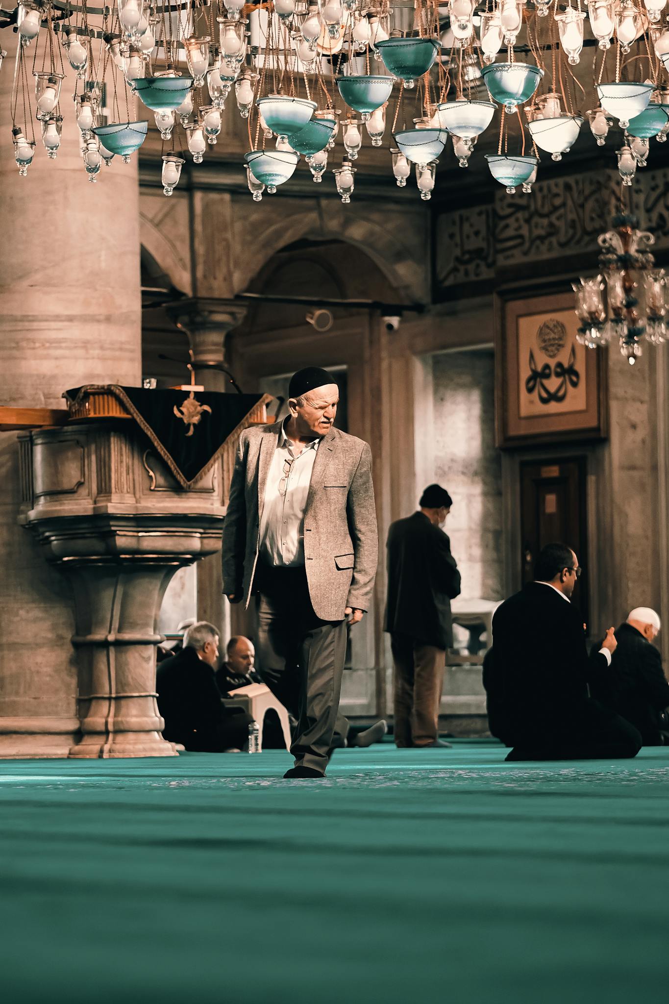 A man walks inside a beautifully ornate mosque, capturing a moment of spiritual reflection.