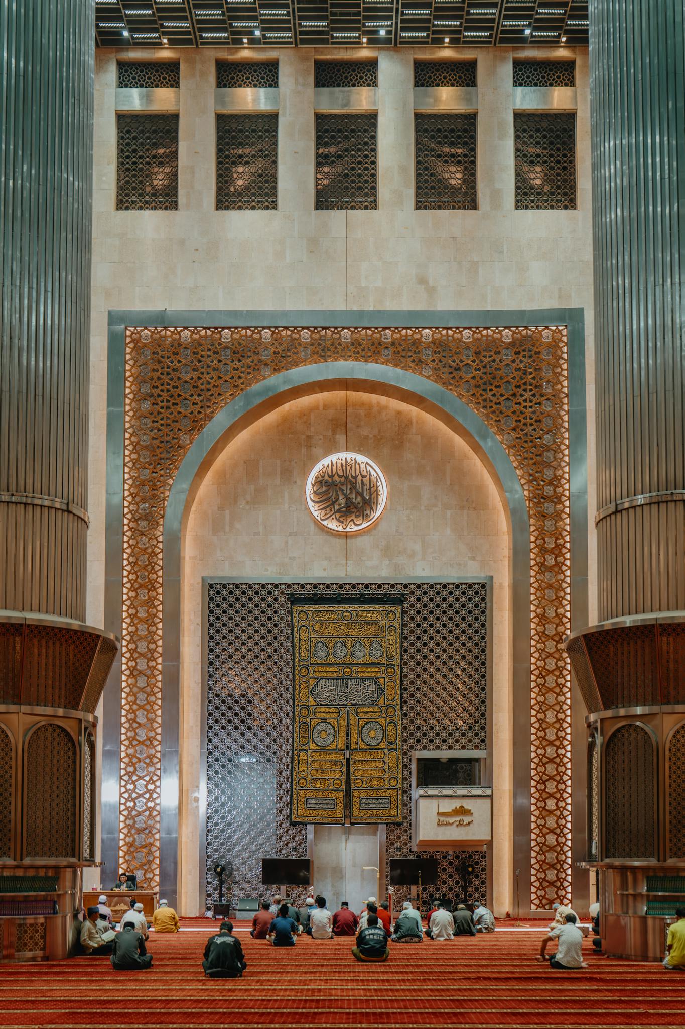 Worshippers gathered in the majestic Istiqlal Mosque, Jakarta, showcasing Islamic architecture.